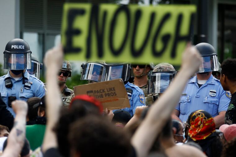 Protesters rally as Philadelphia Police officers and Pennsylvania National Guard soldiers look on, Monday, June 1, 2020, in Philadelphia, over the death of George Floyd, a black man who was in police custody in Minneapolis. Floyd died after being restrained by Minneapolis police officers on May 25. (AP Photo/Matt Slocum)