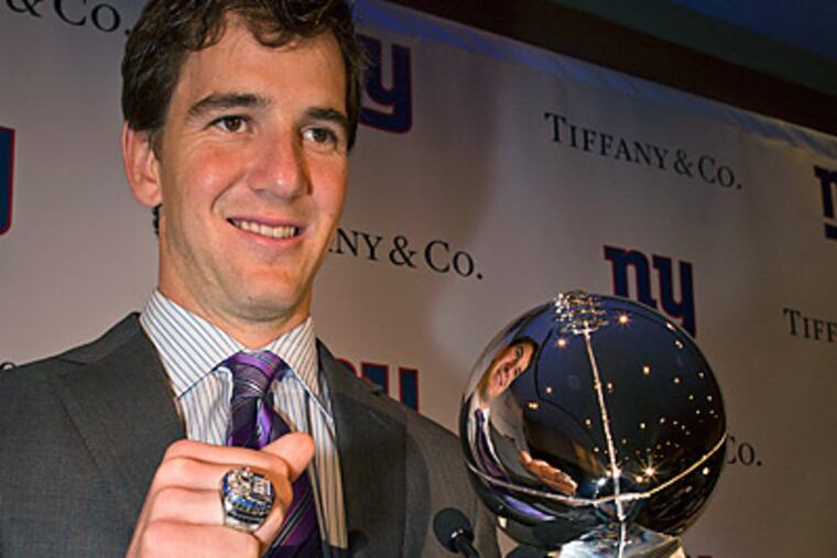 New York Giants quarterback Eli Manning poses with his Super Bowl XLVI ring. (AP Photo/John Minchillo)