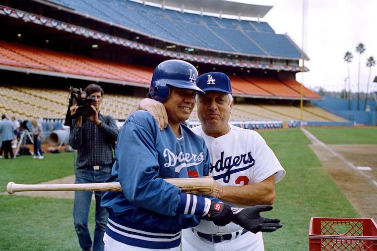 Former Los Angeles Dodgers manager Tommy Lasorda, right, giving a pep talk to star pitcher Fernando Valenzuela as the team prepared for the 1985 National League Championship Series.