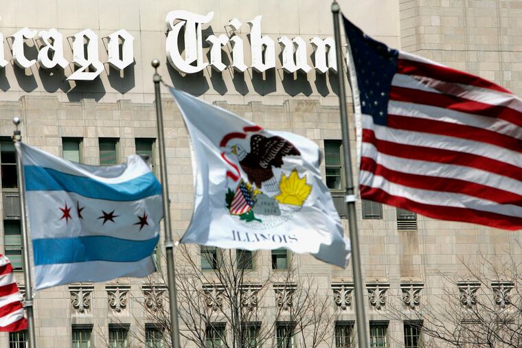 Flags wave near the Chicago Tribune Tower in downtown Chicago. Newspaper publisher Tribune has agreed to be sold to Alden Global Capital, a hedge fund known for cutting costs and eliminating newsroom jobs, in a deal valued at $630 million.