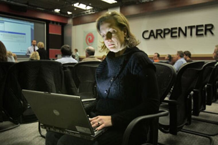 Kristen Haas of Carpenter Technology Corp. in Reading looks into a laptop computer during an online meeting with out-of-town employees rather than spending the money to travel. (Laurence Kesterson / Staff Photographer)