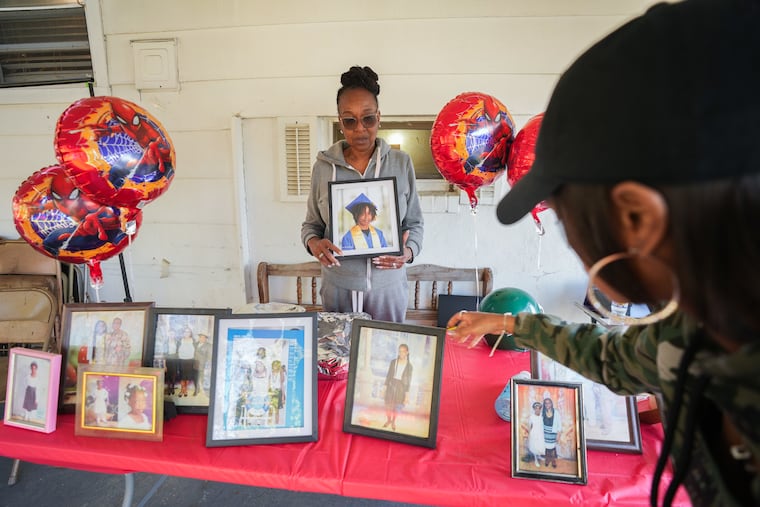 Dietra Bynum holds a graduation photo of her granddaughter Imani Ringgold outside her Delaware County home. Ringgold graduated from YouthBuild, a trade high school in Philadelphia.