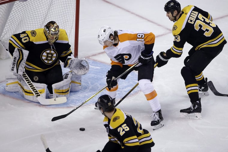 Flyers rookie center Nolan Patrick (19) handles the puck in front of Bruins goaltender Tuukka Rask as Boston defensemen Zdeno Chara (33) and Brandon Carlo (25) help during the first period Thursday.