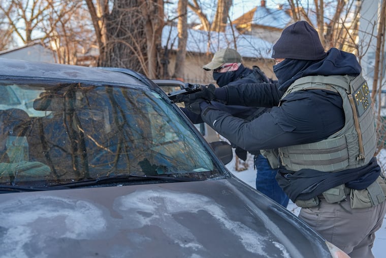 Activists are approached by a federal agent brandishing a firearm, for following agent vehicles, on Tuesday, Feb. 3, 2026, in Minneapolis.