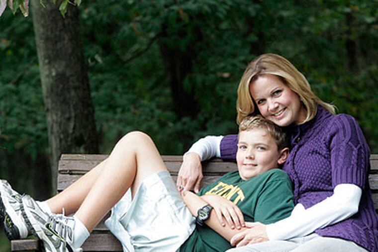 Jeanene Johnston and son Griffin in the backyard swing at their home in Hockessin, Delaware Friday. Jeanene was laid off last January but has just found work. (Bonnie Weller / Staff Photographer)