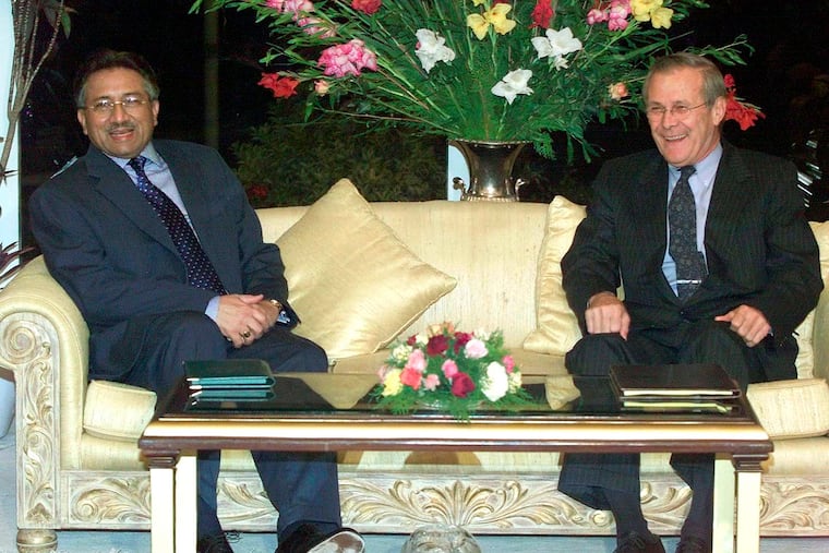 Then-U.S. Secretary of Defense Donald Rumsfeld (right) smiles as he meets with then-President General Pervez Musharraf at the executive residence in Islamabad on Nov. 4, 2001. Musharraf, who seized power in a bloodless coup and later led a reluctant Pakistan into aiding the U.S. war in Afghanistan against the Taliban, died on Feb. 5. He was 79.