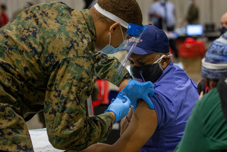 Garry E. Dean, SEPTA Regional Rail station manager, gets vaccinated by a member of the military at the FEMA clinic at the Pennsylvania Convention Center.