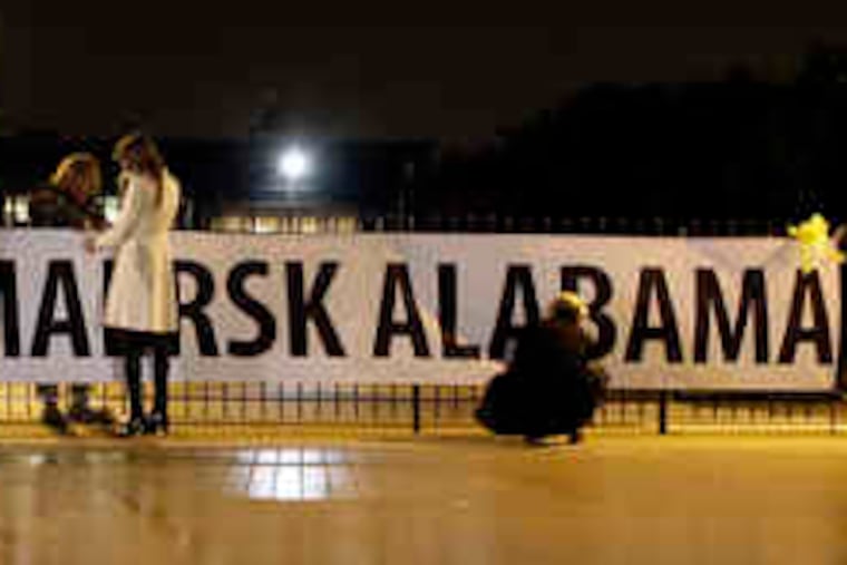 Employees of Maersk hang a welcome-home banner before yesterday's early morning arrival of the Maersk Alabama crew at Andrews Air Force Base, Md.