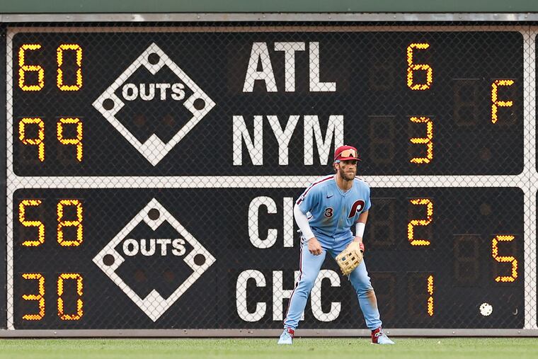 Phillies right fielder Bryce Harper in front of the scoreboard Thursday after the division-leading New York Mets lost to the Atlanta Braves. The Phillies are 3 1/2 games behind the Mets in the National League East.