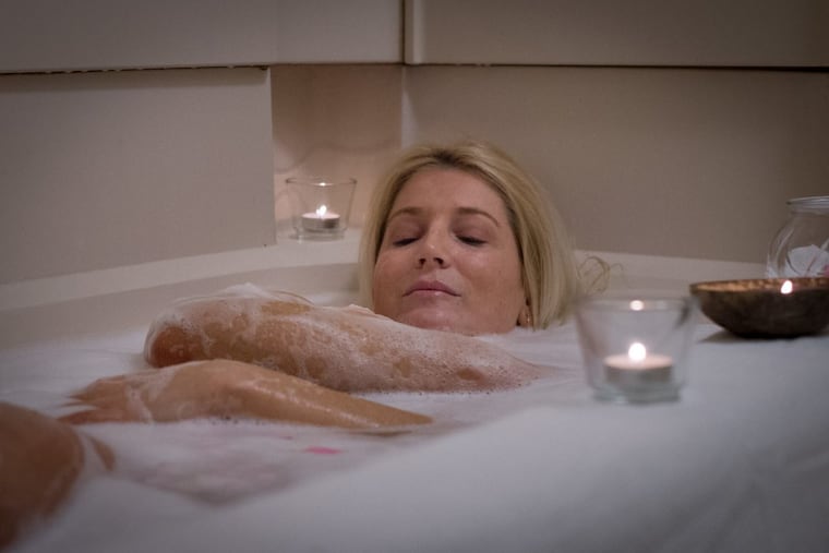 Regan Tilton enjoys a bath with rose petals and scented candles at her home in Center City Philadelphia. Tilton holds two jobs and finds baths at her apartment in Center City Philadelphia to be relaxing and rejuvenating.