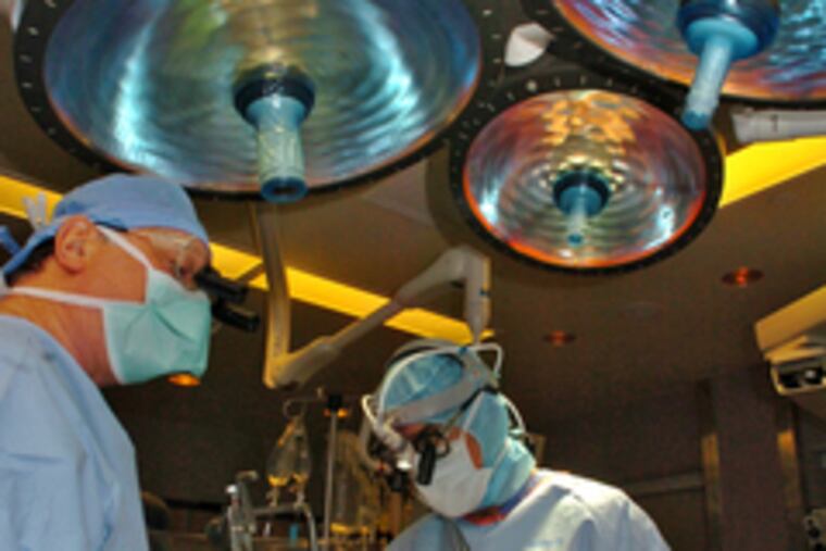 Dr. Francis P. Sutter, with surgical assistant Vincent Merola, harvests an artery for use in the bypass surgery.