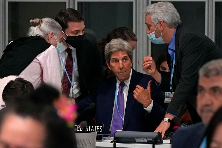 John Kerry, United States Special Presidential Envoy for Climate, center, confers during a stocktaking plenary session at the COP26 U.N. Climate Summit in Glasgow, Scotland, Saturday, Nov. 13, 2021. Going into overtime, negotiators at U.N. climate talks in Glasgow are still trying to find common ground on phasing out coal, when nations need to update their emission-cutting pledges and, especially, on money.