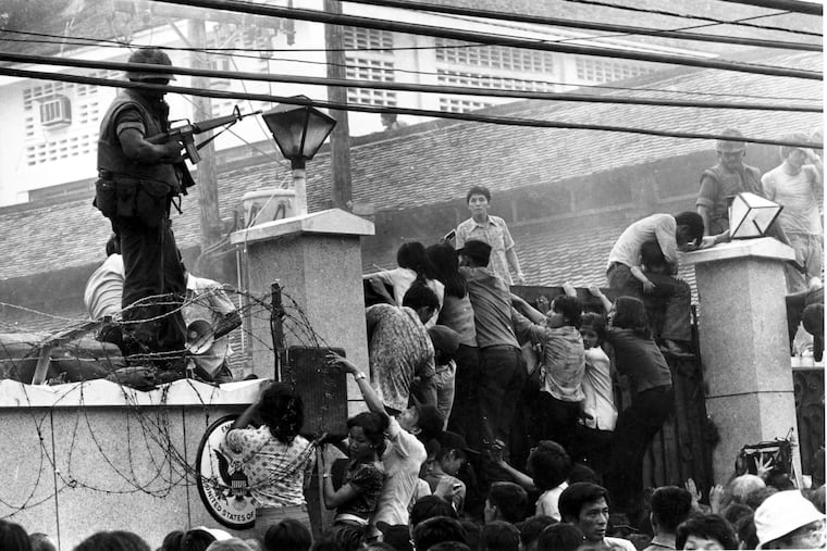 In this April 29, 1975 file photo, Vietnamese people scale the wall of the U.S. Embassy in Saigon, Vietnam, trying to get to the helicopter pickup zone, just before the end of the Vietnam War.