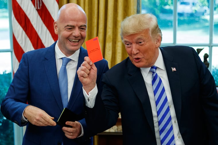 President Donald Trump holds up a red card during a meeting with FIFA president Gianni Infantino in the Oval Office in August 2018.