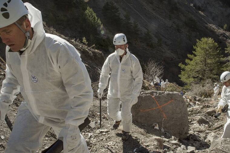 In this photo provided Friday, April 3, 2015 by the French Interior Ministry, French emergency rescue services work among debris of the Germanwings passenger jet at the crash site near Seyne-les-Alpes, France. The co-pilot of the doomed Germanwings flight repeatedly sped up the plane as he used the automatic pilot to descend the A320 into the Alps, the French air accident investigation agency said Friday. (AP Photo/Yves Malenfer, Ministere de l'Interieur)