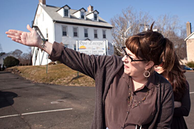 April Fox-Regan points to the close proximity of the proposed Wawa site (behind her) to Hatboro Borough Hall. With her is Heather Hamilton. (Ed Hille / Staff Photographer)