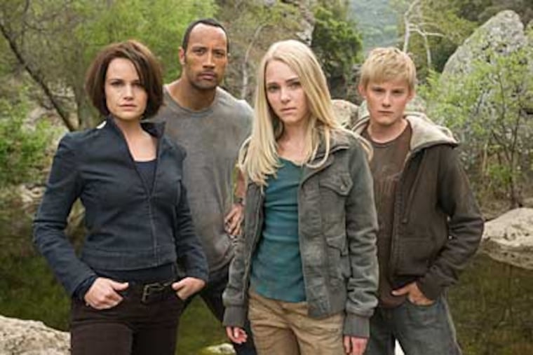 In "Race to Witch Mountain," the quartet of (from left) Carla Gugino, Dwayne Johnson, AnnaSophia Robb, and Alexander Ludwig are pursued by a grim government operative and a space assassin.