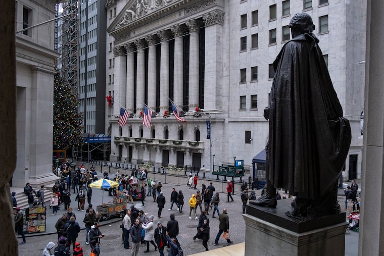 FILE photo shows people walking by a statue of George Washington, adjacent to the New York Stock Exchange. As the 2010s wrap up, Mark Zandi argues that the decade was a pretty good one for the U.S. economy. It was better for the wealthy than working class Americans.