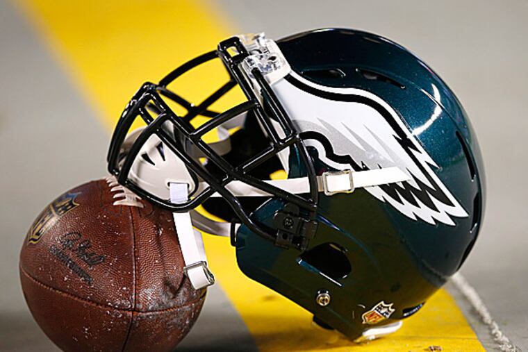 An Eagles helmet rests on a football. (Michael Perez/AP)
