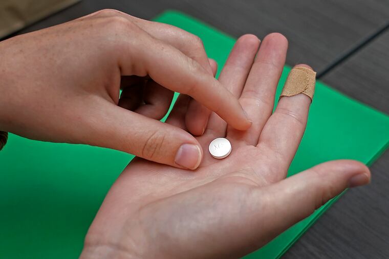 A patient prepares to take the first of two pills for a medication abortion during a visit to a clinic in Kansas City, Kan., in 2022.