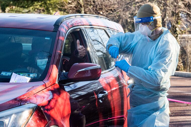 Skyler Wood performs a COVID-19 test in January during a free drive-through testing site at the Mercy Fitzgerald Hospital.