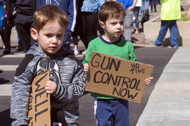 Four-year-old twins Eli, left, and his brother Nathan Hellman hold their signs during the 'March For Our Lives' event on Saturday, March 24, 2018, in Colorado Springs, Colo. The event gained international attention following the mass school shooting that left 17 dead earlier this year in Parkland, Fla.