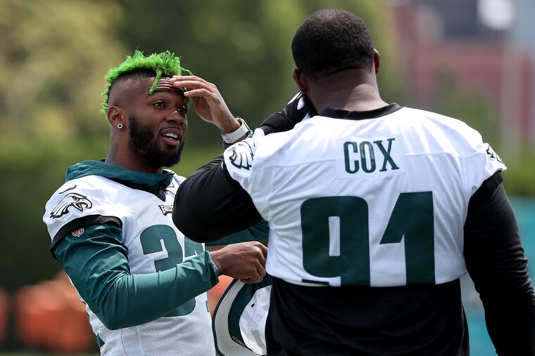 Jalen Mills (left) talks with Fletcher Cox during an Eagles training camp session last month.