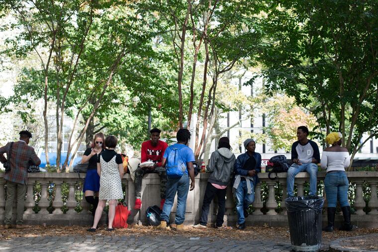 People relax in Rittenhouse Square on Wednesday, the morning after a shooting.