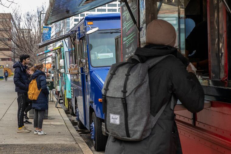 People line up at various food trucks outside of Drexel University at Market Street between 33rd and 34th in Philadelphia on Dec. 11, 2019.