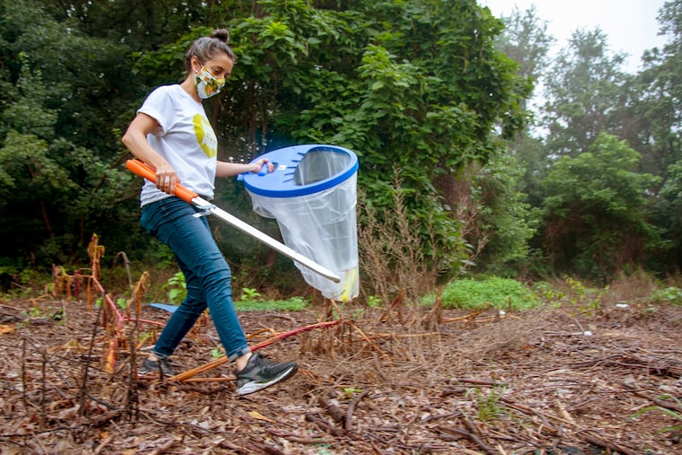 Lindsey Walker, the volunteer and environmental program manager at the Fairmount Park Conservancy, picks up trash in Fairmount Park on Aug. 13, 2020, as part of the Love Your Park Solo Cleanup campaign.