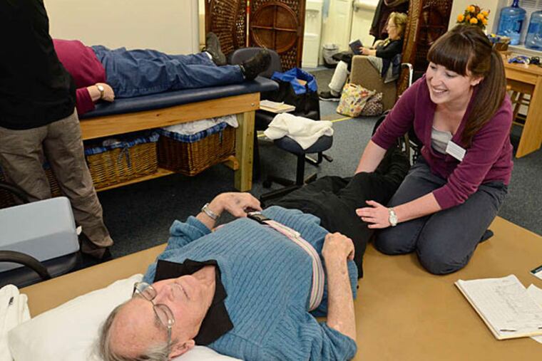 Courtney Christman, a physical therapy student at the clinic at Widener University, helps Bill Weir with a leg problem. The clinic, run by graduate students, is free to Chester residents. (Ron Tarver/Staff)