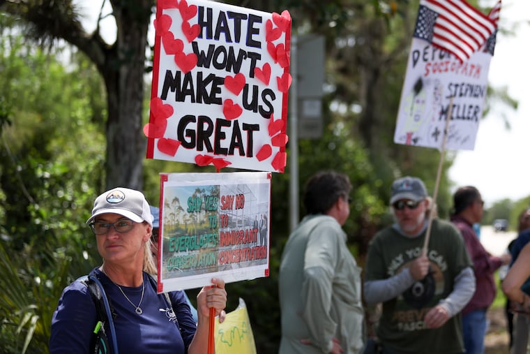 A protester stands outside the migrant detention facility dubbed “Alligator Alcatraz” at the Dade-Collier Training and Transition Facility in Ochopee, Fla., in July.