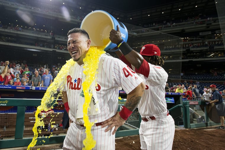 Wilson Ramos, gets a cooler dumped on him by fellow Venezuelan Odubel Herrera after his first game as a Phillie.