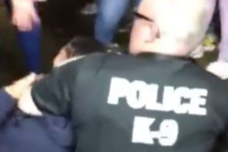 A Norristown police officer holds down a 14-year-old at a church sponsored carnival in Norristown on Saturday.