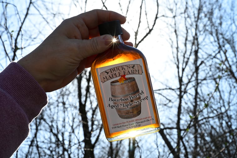 Sherry Hess holds a pint of Bourbon Barrel Aged Maple Syrup at Duck's Maple Farm, a sugar camp she and her husband operate in Normalville, Pa.