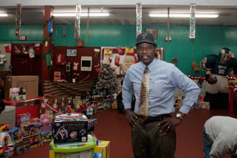The Rev. Al Stewart among toy donations at the Mission in Camden. ( Bonnnie Weller / Staff Photographer )