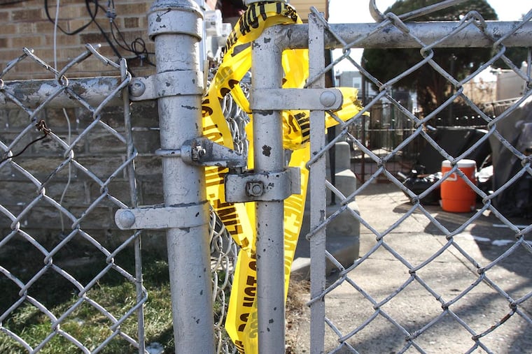 Police crime tape rests on a fence outside the scene of a shooting at 4600 Vista Street, leaving three people dead in Philadelphia, Pa. on January 11, 2015. ( DAVID MAIALETTI / Staff Photographer )