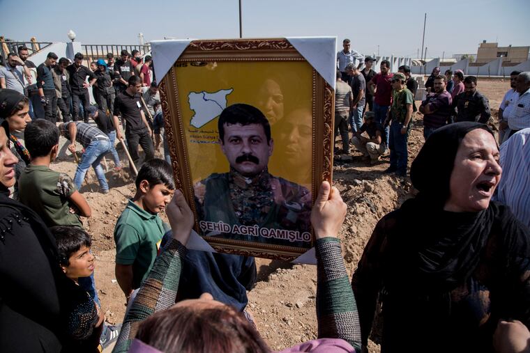 People attend funerals of fighters of the Syrian Democratic Forces killed fighting Turkish advance, in the town of Qamishli, northern Syria, Wednesday, Oct. 16, 2019.