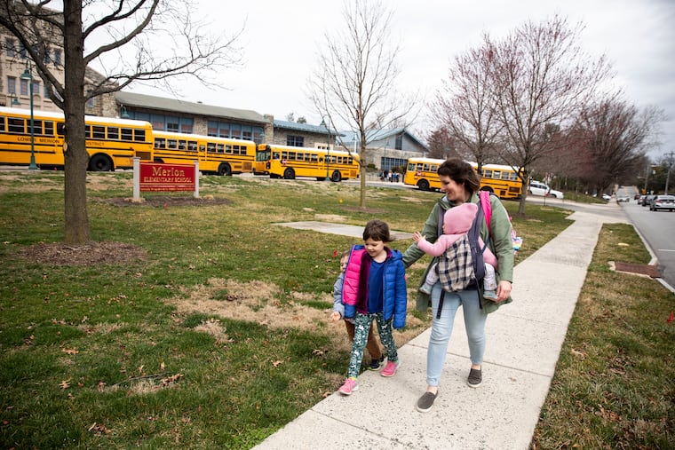 Henry Olah, 4, leaves Merion Elementary with his sisters, Eloise and Margaret and their mom Annie Olah during early dismissal on Thursday. The Lower Merion School District will be closed for the next two weeks along with other Montgomery County schools as part of a state order to stem the spread of the coronavirus.