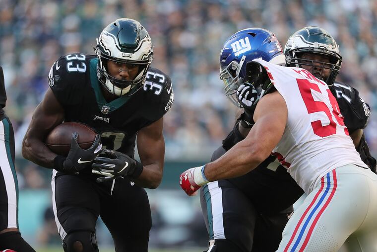Eagles Josh Adams, left, runs in the 3rd quarter as Jason Peter, right, blocks the Giants Olivier Vernon, center. Philadelphia Eagles win 25-22 over the New York Giants in Philadelphia, PA on November 25, 2018. DAVID MAIALETTI / Staff Photographer