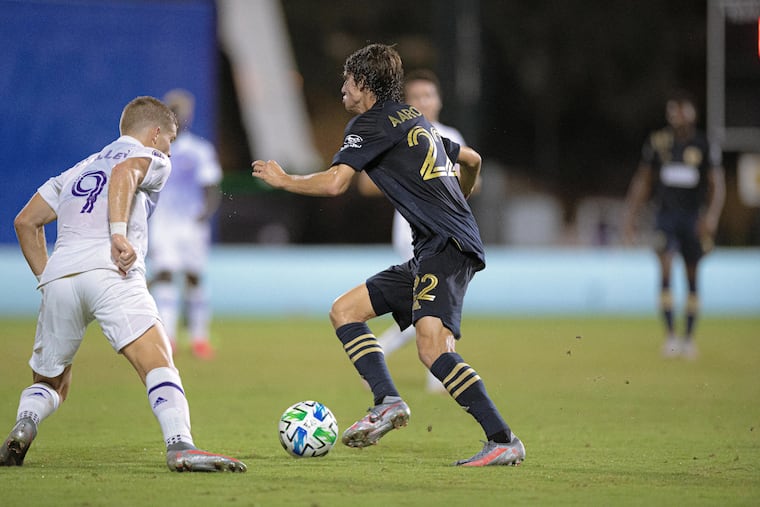 Union midfielder Brenden Aaronson dribbling toward Orlando City forward Chris Mueller during the second half.