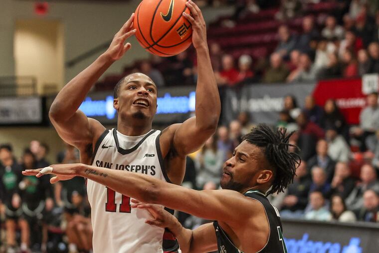 Saint Joseph’s Xzayvier Brown goes up for a shot past George Mason’s Darius Maddox in the second half of a game at Hagan Arena in Philadelphia on Wednesday, Jan. 31, 2024. The Hawks won, 75-73.