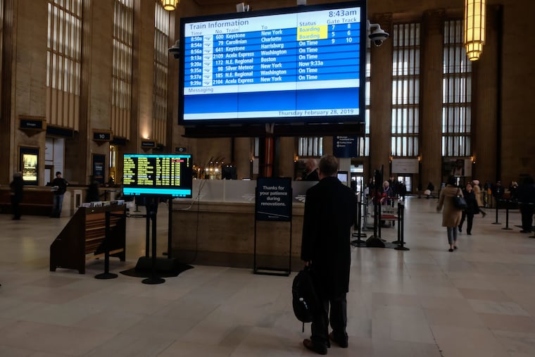 An Amtrak passenger checks the new digital schedule board at 30th Street Station.
