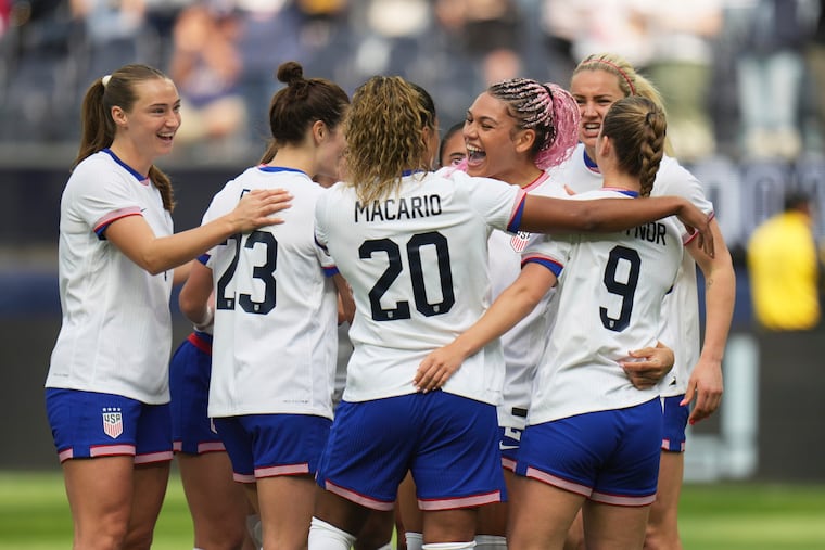 Trinity Rodman, wearing her famed pink braids, celebrates with teammates after her goal.