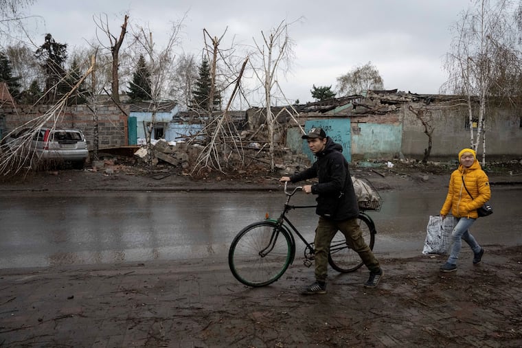 Locals walk past a house which was destroyed by Russian attack in Kostiantynivka, Ukraine.