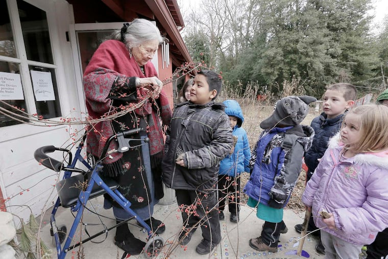 Artist Pat Witt (left) shows Neftali Garcia, 8, and other young art students a bittersweet vine.