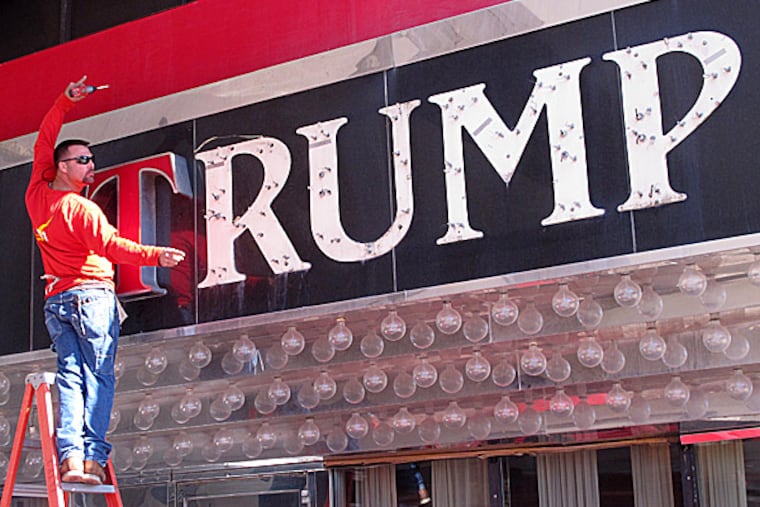 A worker unscrews letters from facade of the former Trump Plaza casino. (Wayne Parry/AP)