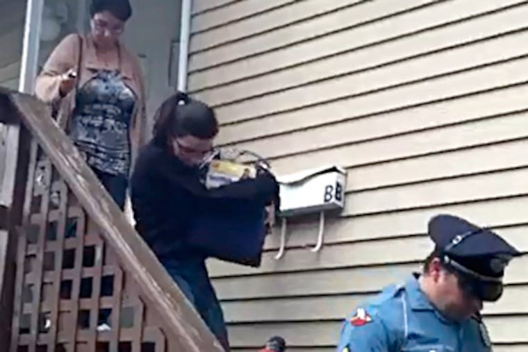 Pedro Hernandez's wife and daughter leave their home with police help as the daughter carries a box of items. (Darran Simon / Staff)