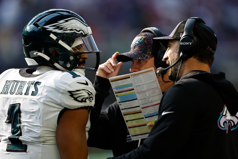 Eagles coach Nick Sirianni (right) talking to quarterback Jalen Hurts with offensive coordinator Kevin Patullo during the win against the Vikings.
