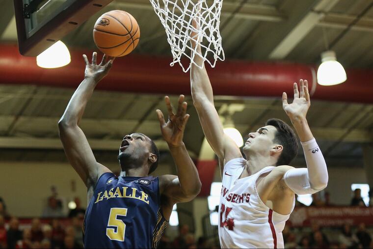 La Salle's Tony Washington (5) puts the ball up past Saint Joseph's Pierfrancesco Oliva (24) during a game at Hagan Arena on Saturday, March 3, 2018. Saint Joseph's won 78-70. TIM TAI / Staff Photographer